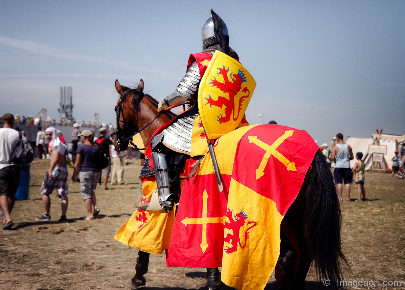 A knight on horseback, yellow and read coat of arms