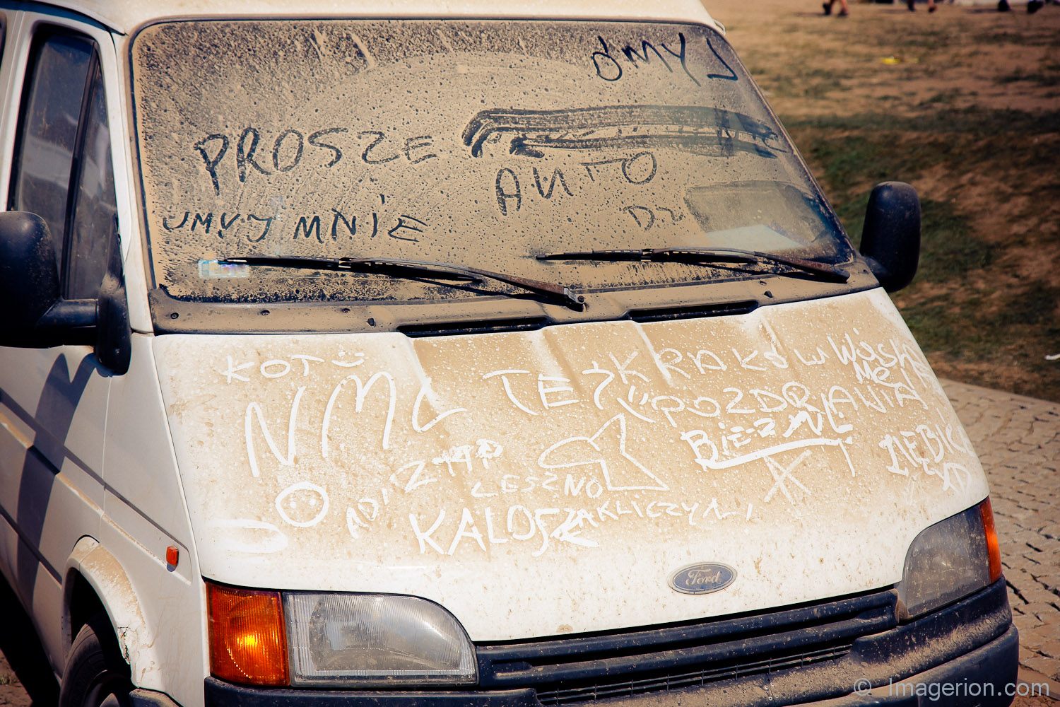 White car covered with the dust and inscriptions on it